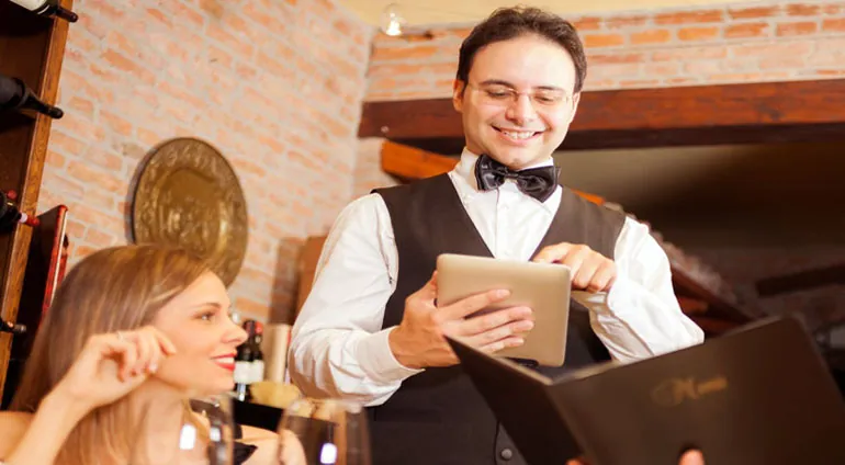 نادل يأخذ طلب الطاولة بجهاز لوحي ببرنامج أكسو ون للمطاعم
